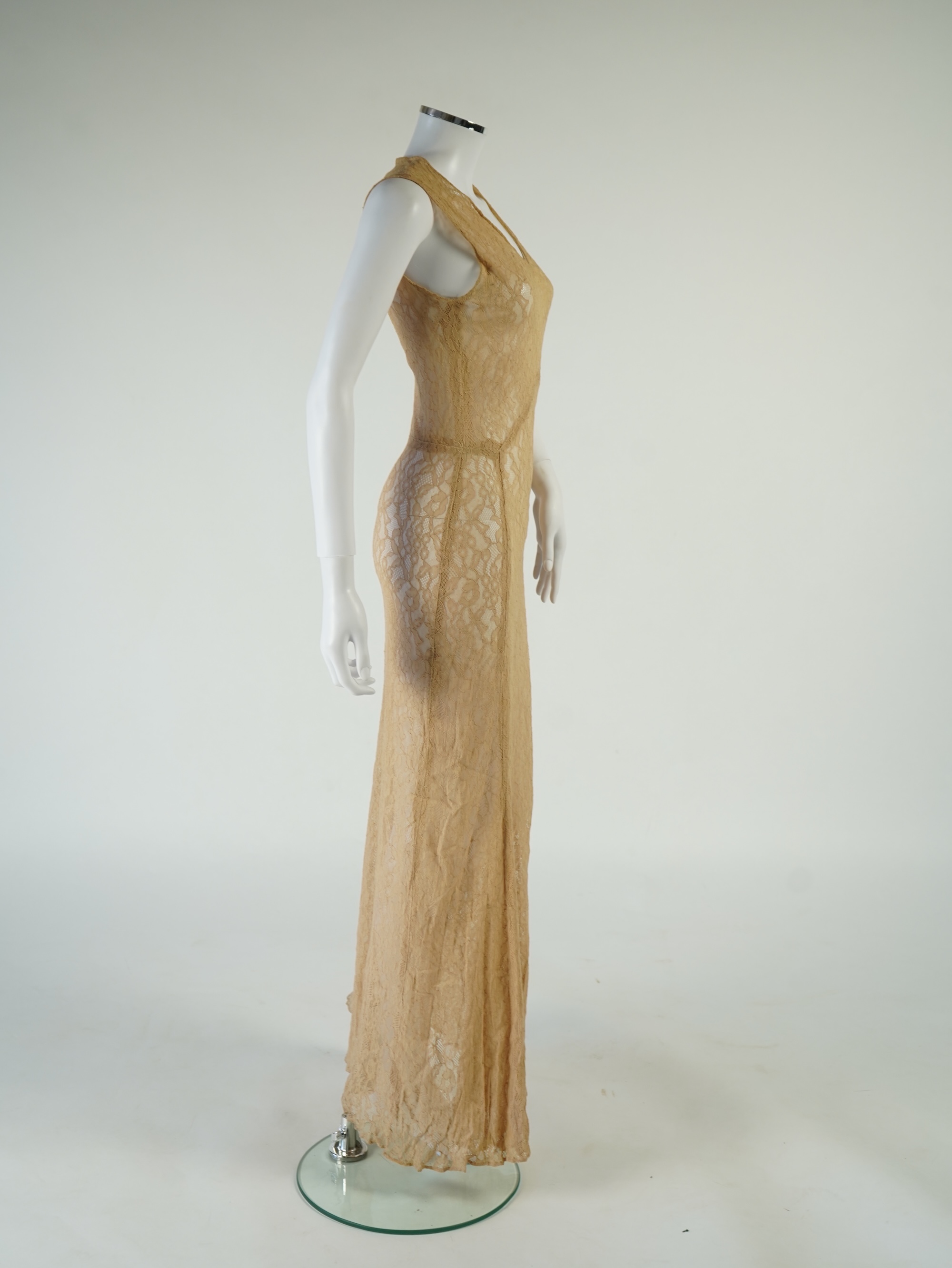 A flesh coloured 1930s lace evening dress and matching jacket together with a bottle green velvet evening dress and buckle belt and an unusual green shot silk pleated under skirt. Lace dress bust 32 inches. 156cm long. C